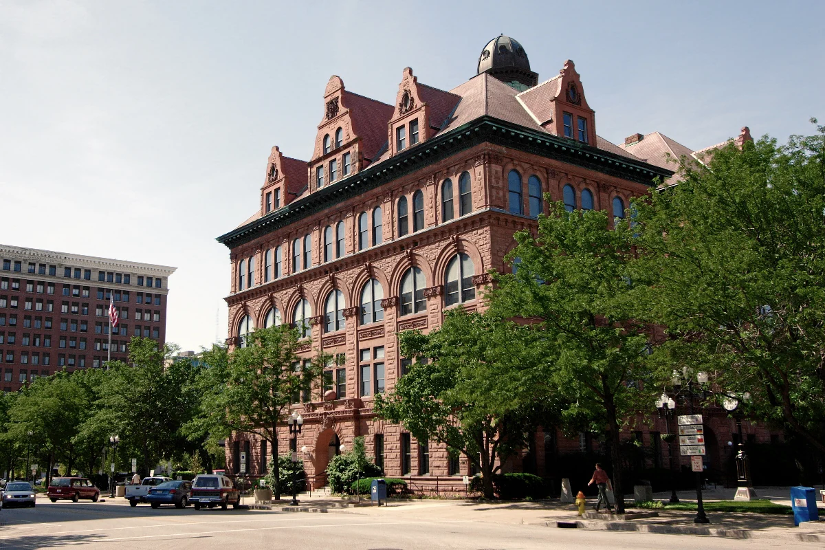 Peoria City Hall’s red stone facade and towers, viewed from a street corner.