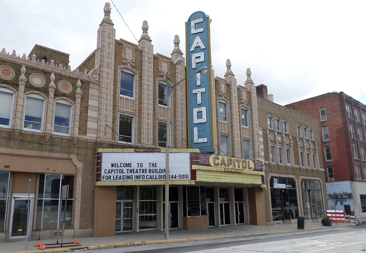 The Capitol Theatre’s decorative façade and tall blue Capitol sign in Flint.