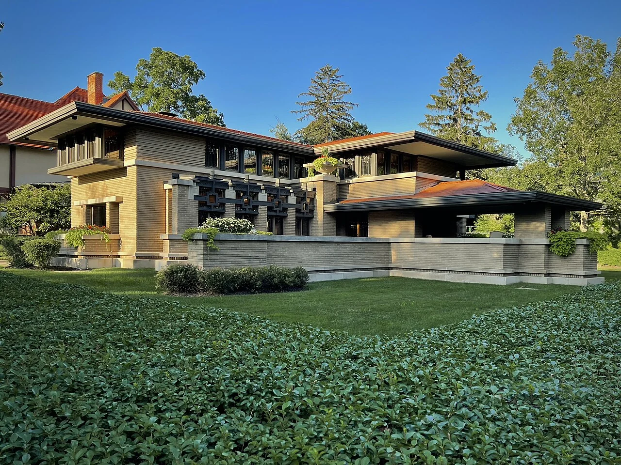 The Meyer May House in Grand Rapids, with broad overhanging roofs and a landscaped lawn.