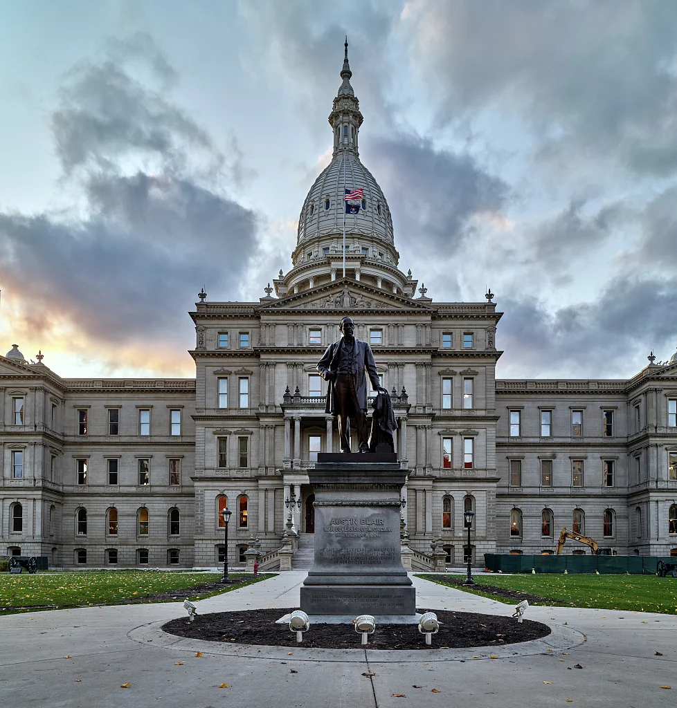 The Michigan State Capitol in Lansing, with its dome and the Austin Blair statue in the foreground.