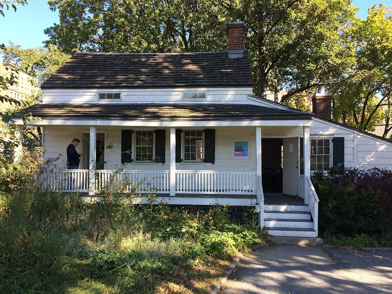 The white wooden Edgar Allan Poe Cottage and its front porch in the Bronx.