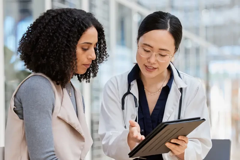 A patient and clinician review health information on a tablet